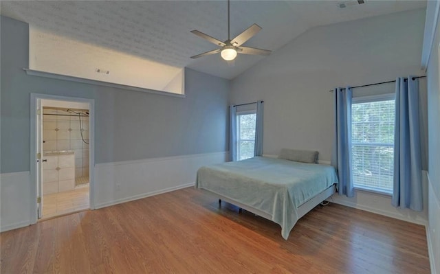 bedroom with vaulted ceiling, wood finished floors, and visible vents
