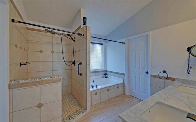 full bath with a sink, a bath, double vanity, a tile shower, and lofted ceiling