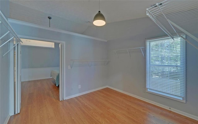 interior space with vaulted ceiling, wood finished floors, and baseboards