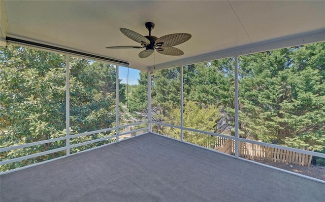 unfurnished sunroom featuring ceiling fan