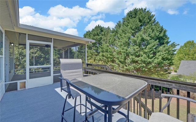 wooden terrace featuring outdoor dining space and a sunroom