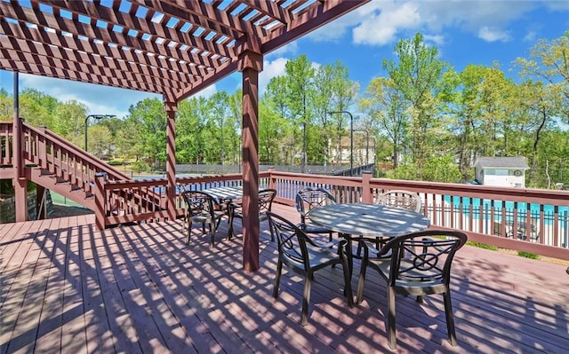 wooden deck featuring a pergola, fence, outdoor dining space, and stairs