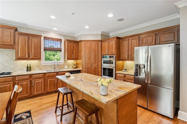 11259 Calypso Dr, Alpharetta, GA 30009 - kitchen featuring stainless steel appliances, a sink, brown cabinets, light stone counters, and recessed lighting