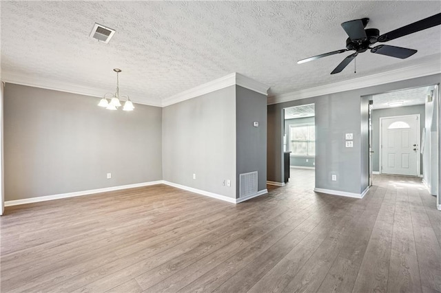 unfurnished room with hardwood / wood-style flooring, visible vents, and ornamental molding