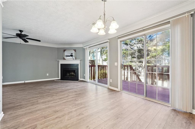 unfurnished living room featuring ornamental molding, a fireplace with raised hearth, a textured ceiling, and wood finished floors