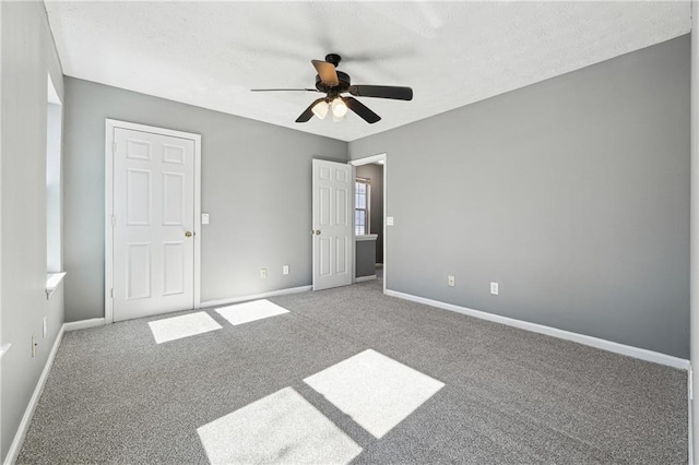 unfurnished bedroom featuring carpet floors, baseboards, and a ceiling fan