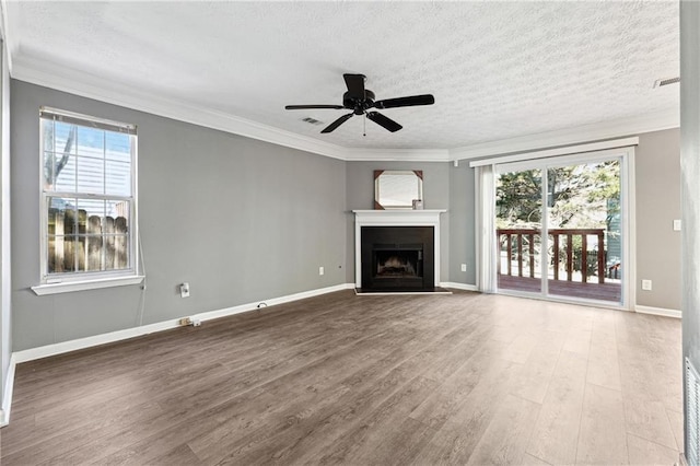 unfurnished living room featuring ornamental molding, plenty of natural light, and wood finished floors