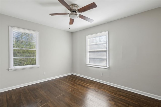 empty room featuring ceiling fan, a healthy amount of sunlight, and dark hardwood / wood-style floors