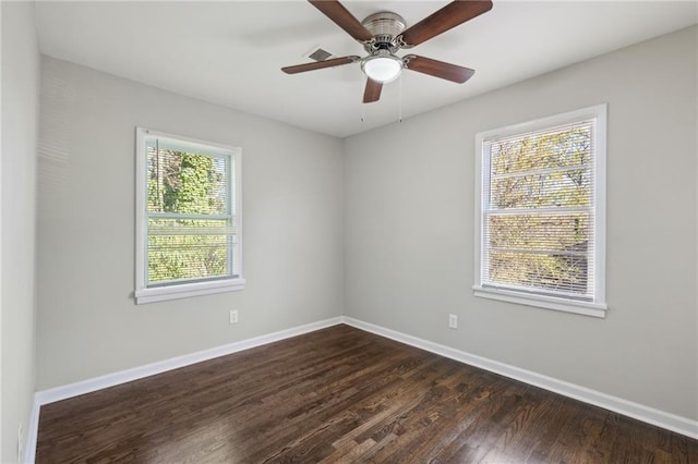 empty room featuring ceiling fan, dark hardwood / wood-style floors, and a wealth of natural light