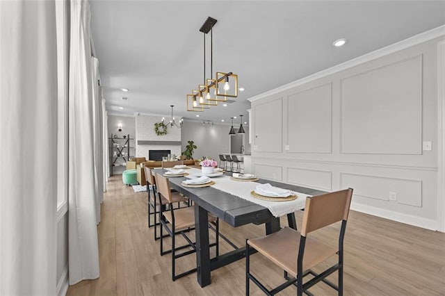 940 Emmett Walk, Alpharetta, GA 30004 - dining area featuring light wood finished floors, recessed lighting, a brick fireplace, crown molding, and a chandelier