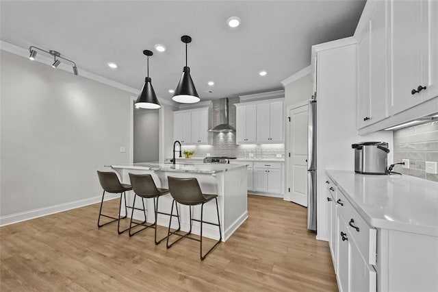 940 Emmett Walk, Alpharetta, GA 30004 - kitchen with wall chimney range hood, a kitchen breakfast bar, tasteful backsplash, light countertops, and white cabinets