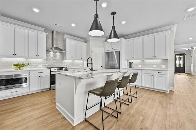 940 Emmett Walk, Alpharetta, GA 30004 - kitchen with stainless steel appliances, wall chimney range hood, ornamental molding, backsplash, and white cabinetry