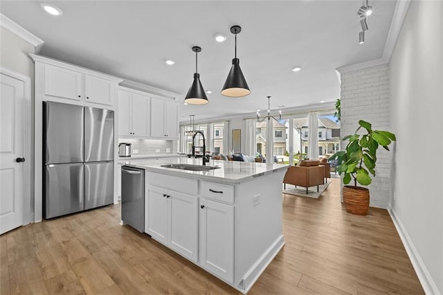 940 Emmett Walk, Alpharetta, GA 30004 - kitchen featuring appliances with stainless steel finishes, white cabinets, light wood-type flooring, crown molding, and a center island with sink