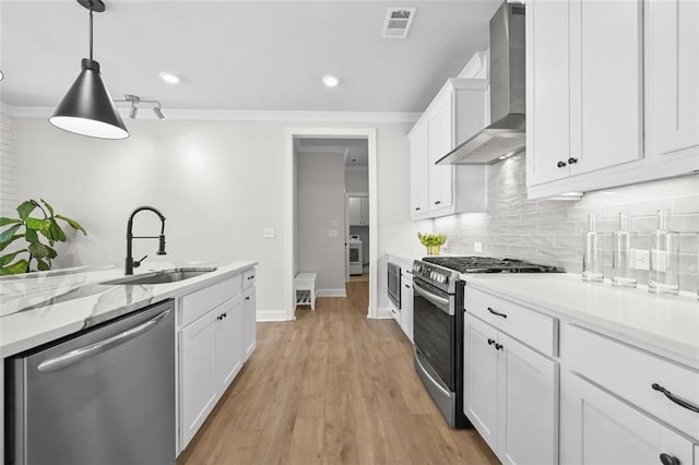 940 Emmett Walk, Alpharetta, GA 30004 - kitchen featuring appliances with stainless steel finishes, wall chimney range hood, white cabinets, backsplash, and light wood-style floors