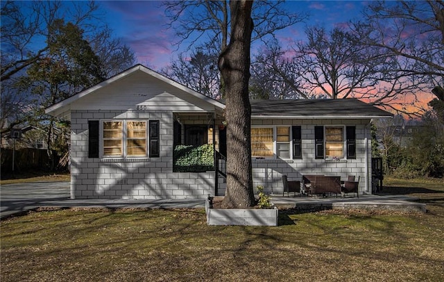 view of front of house with a patio and a lawn