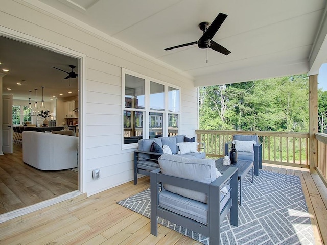 wooden terrace with an outdoor living space and ceiling fan