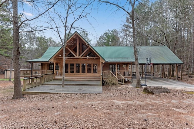 view of front of home with a porch, metal roof, and driveway