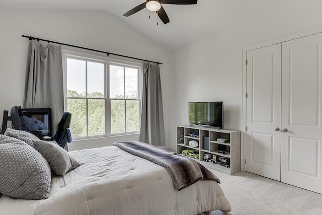 carpeted bedroom with multiple windows, ceiling fan, and lofted ceiling