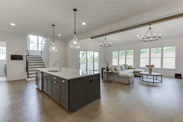kitchen with a sink, light countertops, a notable chandelier, and a healthy amount of sunlight