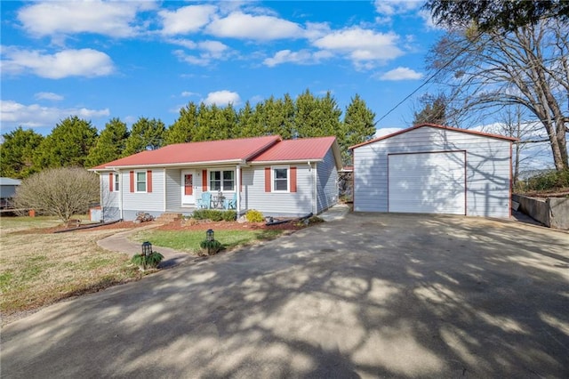 ranch-style home with a porch, an outbuilding, a front yard, and a garage