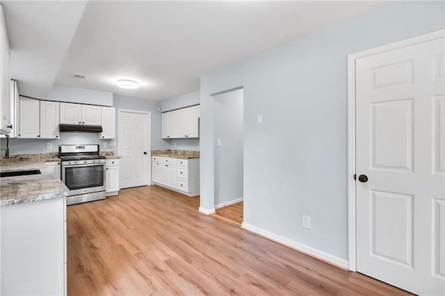 8914 Gardener Dr, Jonesboro, GA 30238 - kitchen with stainless steel gas range oven, under cabinet range hood, white cabinets, and light wood-style floors