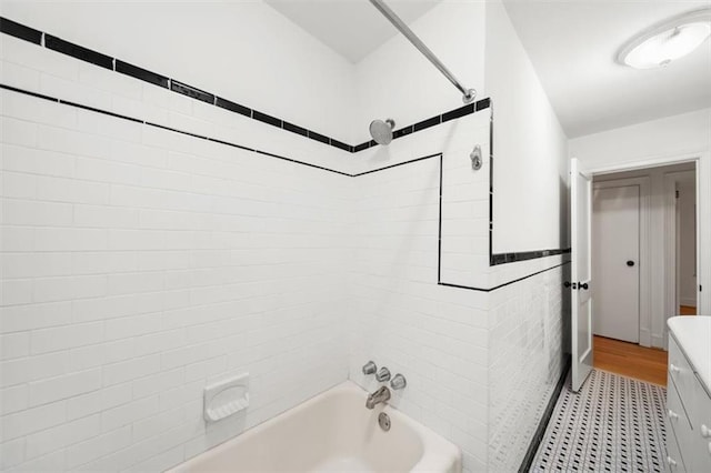 bathroom with tiled shower / bath and tile walls