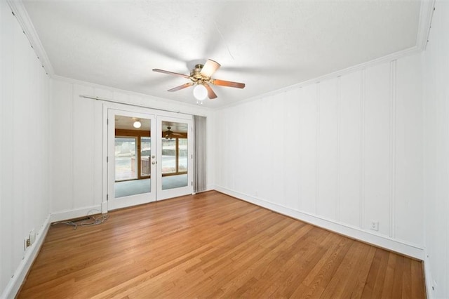 spare room featuring hardwood / wood-style flooring, ornamental molding, ceiling fan, and french doors