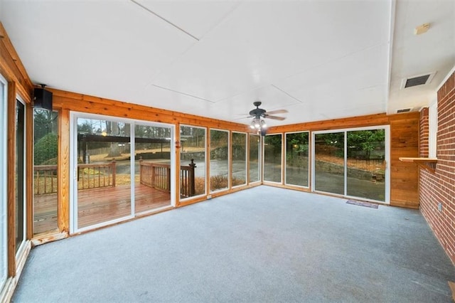 unfurnished sunroom featuring ceiling fan