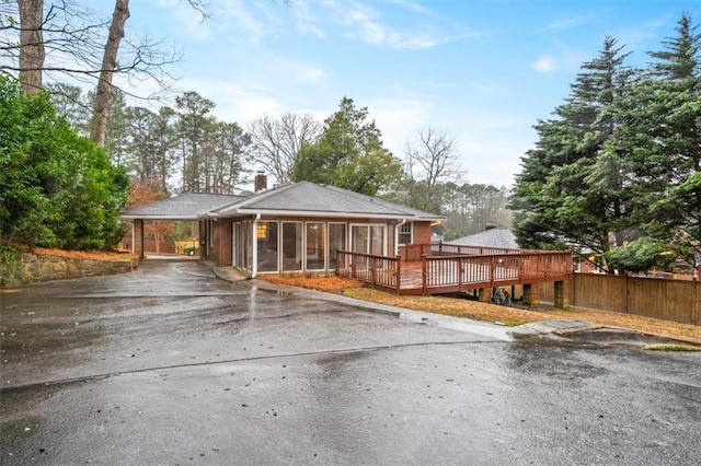 view of front of property with a wooden deck and a sunroom