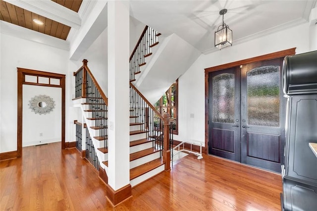 entryway featuring french doors, hardwood / wood-style floors, beam ceiling, wood ceiling, and a notable chandelier