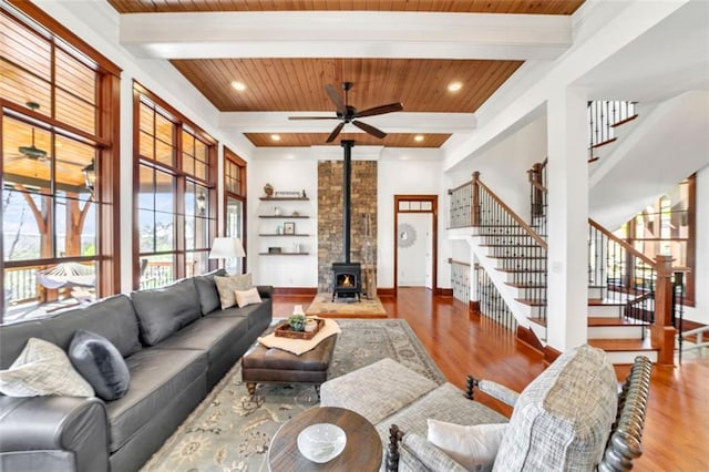 living room featuring wooden ceiling, ceiling fan, a wood stove, and hardwood / wood-style floors