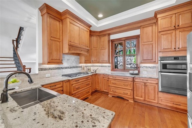 kitchen with light stone counters, appliances with stainless steel finishes, tasteful backsplash, and light wood-type flooring