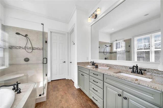 bathroom featuring hardwood / wood-style flooring, ornamental molding, shower with separate bathtub, and double sink vanity