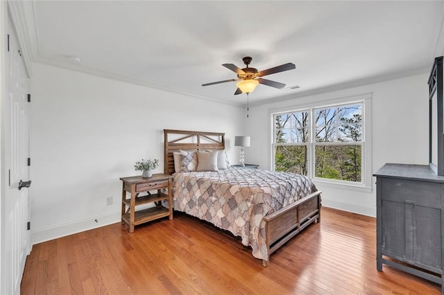 bedroom featuring ceiling fan, crown molding, and light wood-type flooring