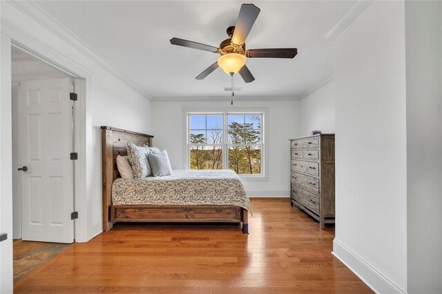 bedroom with crown molding, ceiling fan, and hardwood / wood-style floors