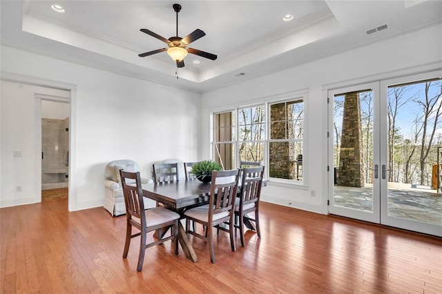 dining room with a tray ceiling, french doors, ceiling fan, and hardwood / wood-style floors