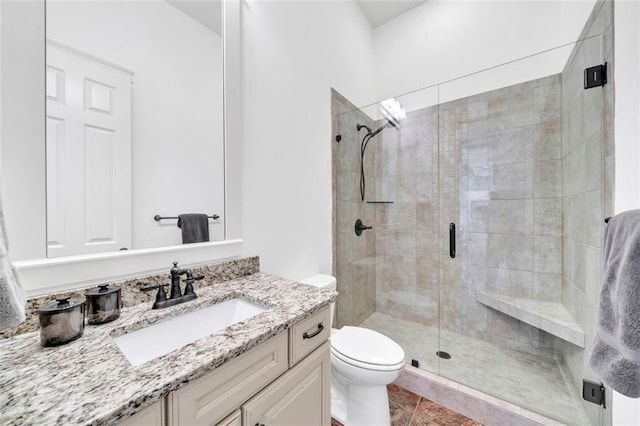 bathroom with tile flooring, an enclosed shower, vanity, and toilet