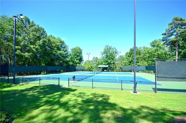 view of tennis court featuring a yard