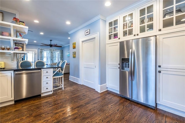 kitchen featuring crown molding, appliances with stainless steel finishes, dark wood-type flooring, and white cabinets