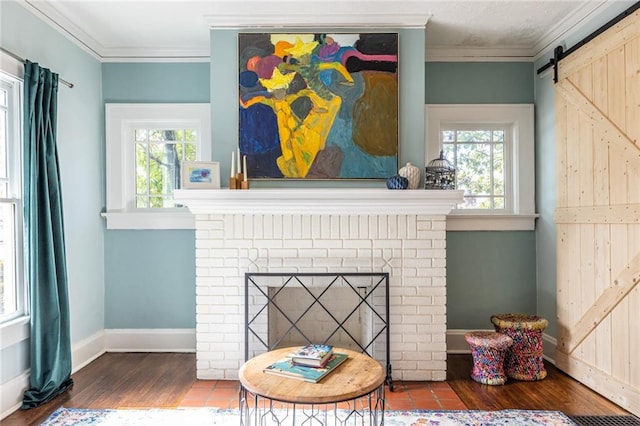 interior details with a brick fireplace, crown molding, wood-type flooring, and a barn door