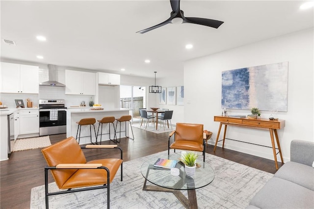 living room with dark hardwood / wood-style flooring and ceiling fan