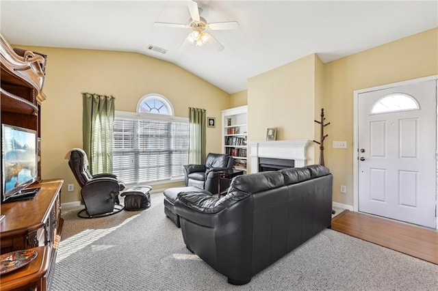 living room featuring lofted ceiling, carpet floors, and ceiling fan