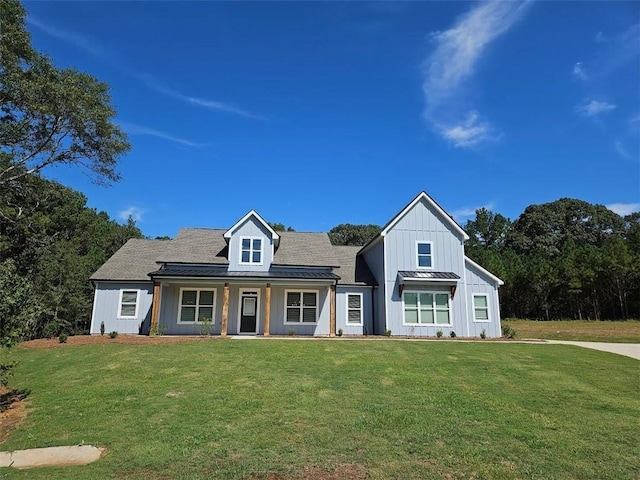 modern inspired farmhouse featuring a standing seam roof, board and batten siding, and a front yard