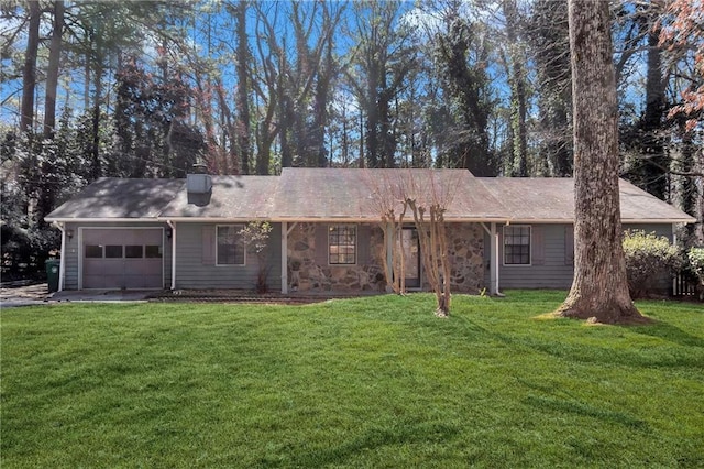 rear view of house featuring a yard, stone siding, a chimney, and an attached garage