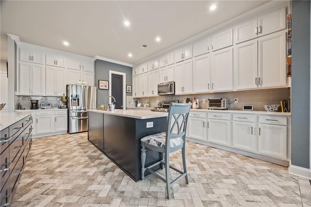 kitchen with recessed lighting, light countertops, white cabinets, backsplash, and stainless steel appliances