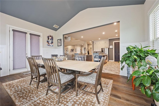 dining area featuring wainscoting, visible vents, dark wood-style floors, and a decorative wall