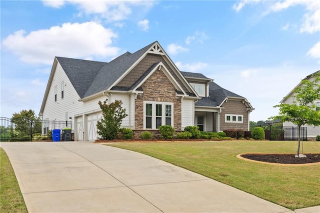 craftsman inspired home with a front yard, fence, driveway, and stone siding