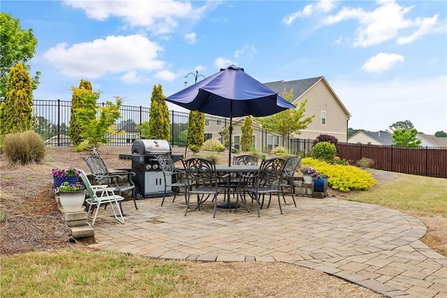 view of patio with outdoor dining area, a fenced backyard, and a grill