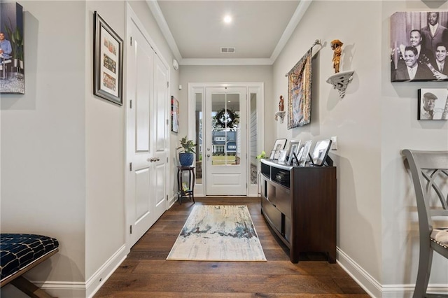 doorway to outside featuring crown molding, dark wood-style flooring, baseboards, and visible vents