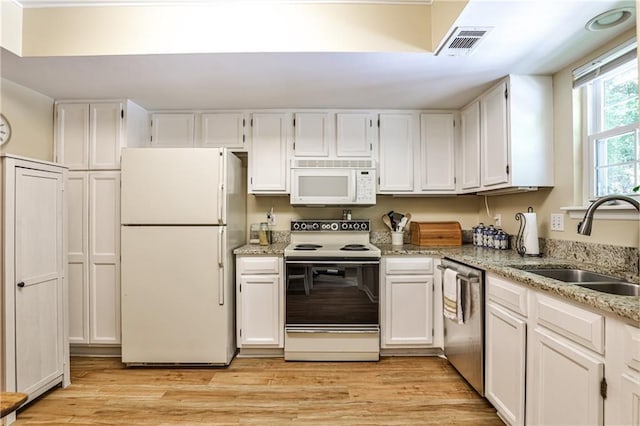 1750 Clairmont Rd Unit 35, Decatur, GA 30033 - kitchen with white appliances, a sink, white cabinetry, light stone counters, and light wood-type flooring